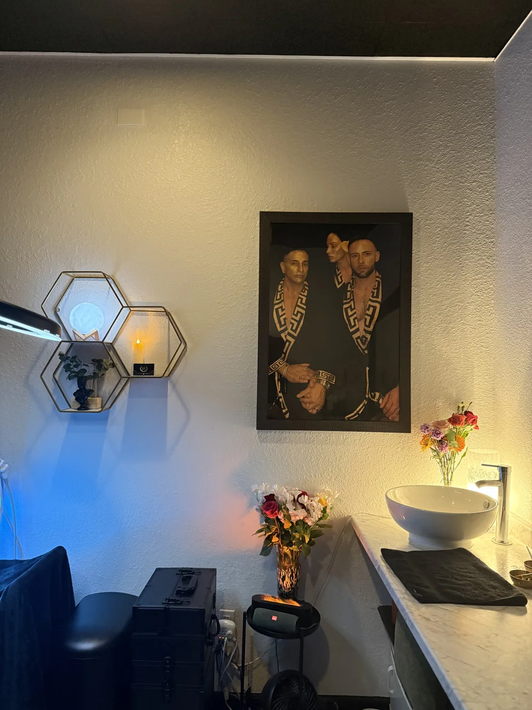 Studio wall with artwork, shelving and fresh flowers